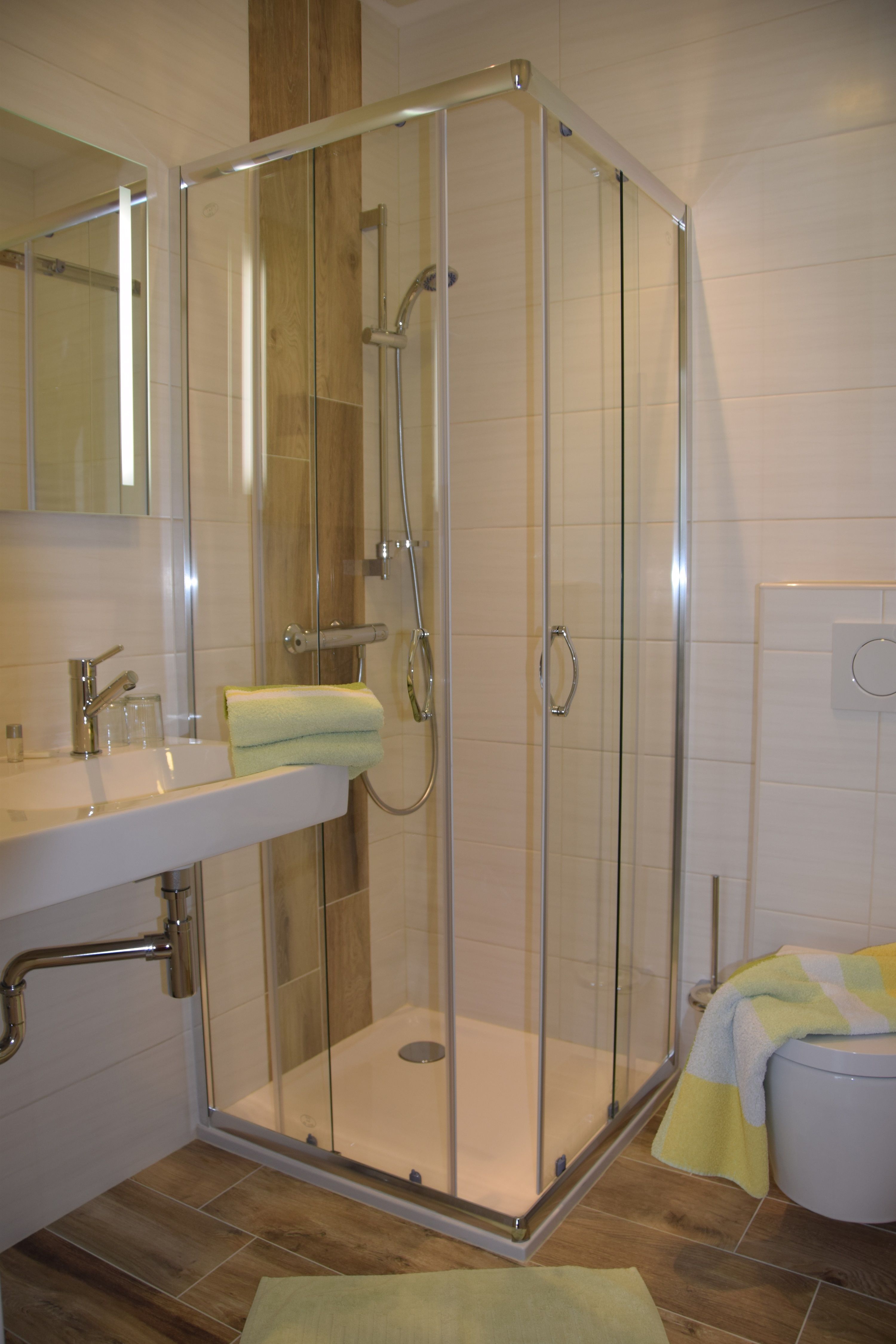Modern bathroom with shower cubicle, washbasin and toilet.
