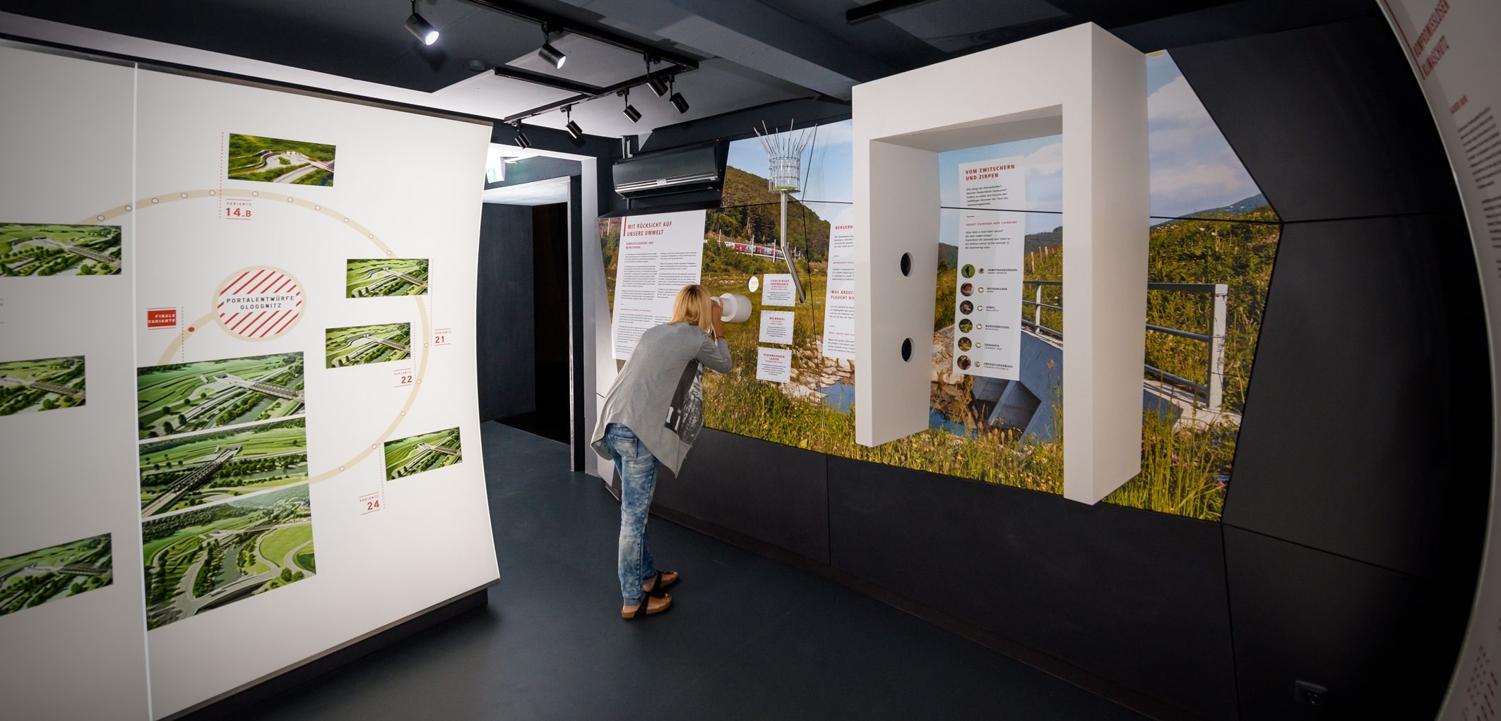 A person looks at an exhibition in a modern information center with pictures and texts on the walls.