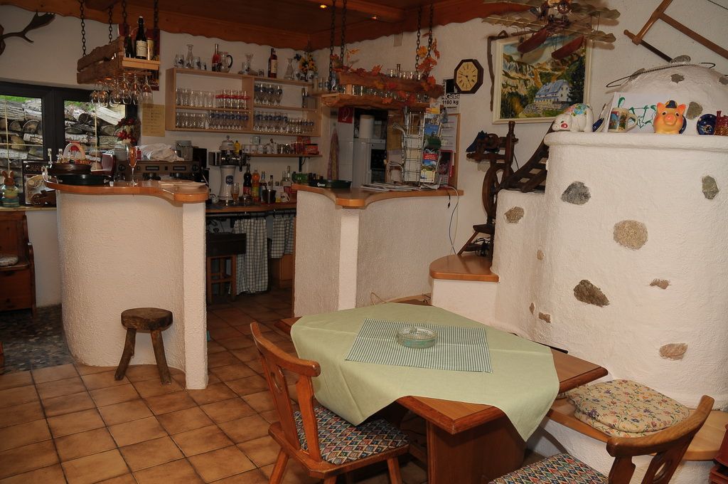 Cozy mountain hut with rustic furnishings and bar area.