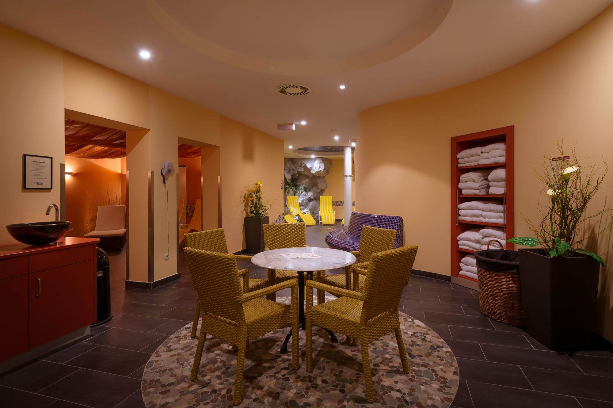 Wellness area of a hotel with table, chairs and loungers.