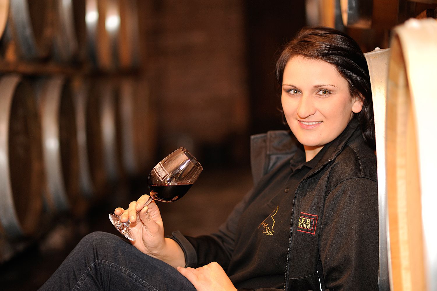 Woman with wine glass in a wine cellar.