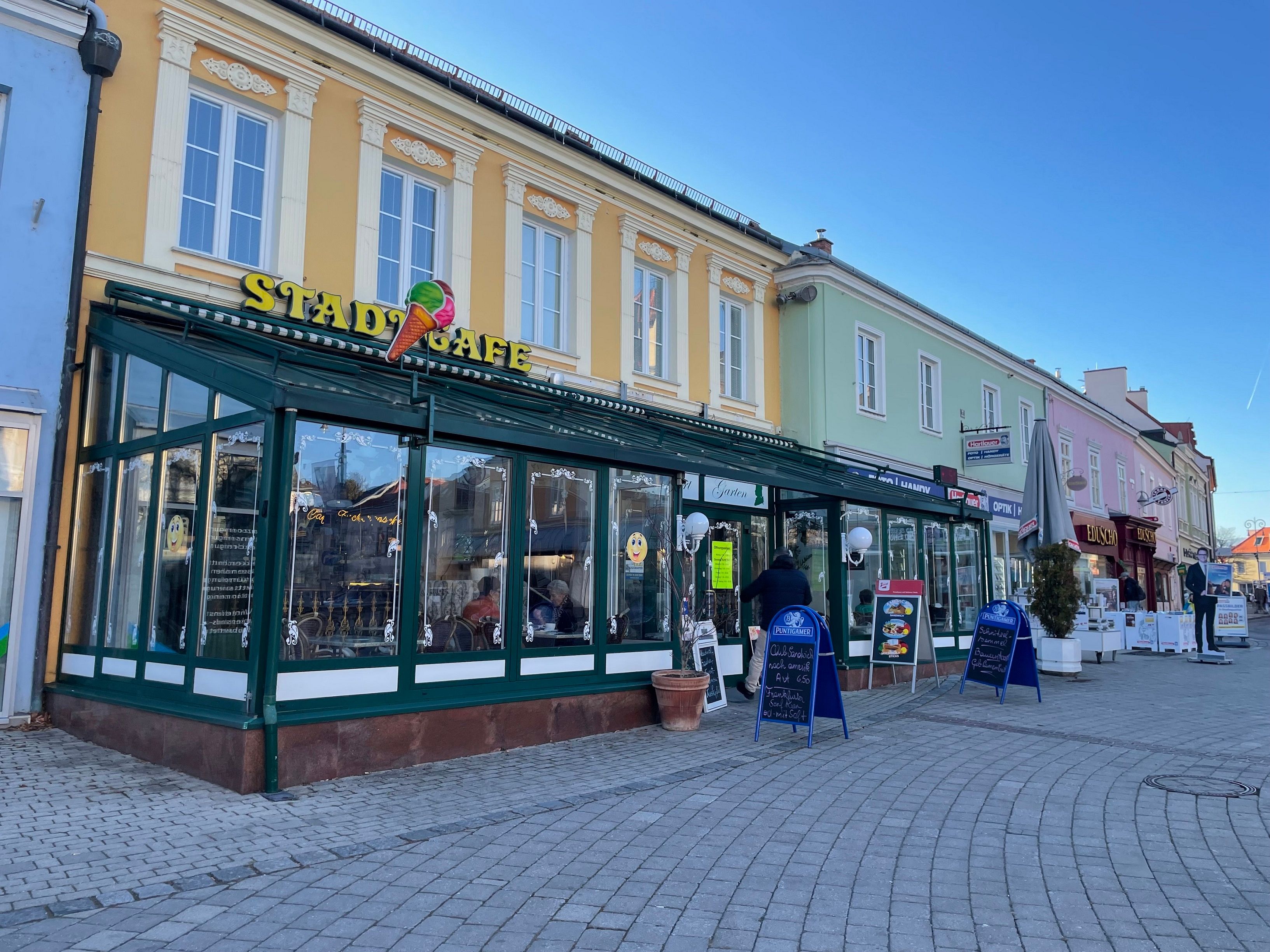 Exterior view of a café with a yellow façade and ice cream parlor sign.
