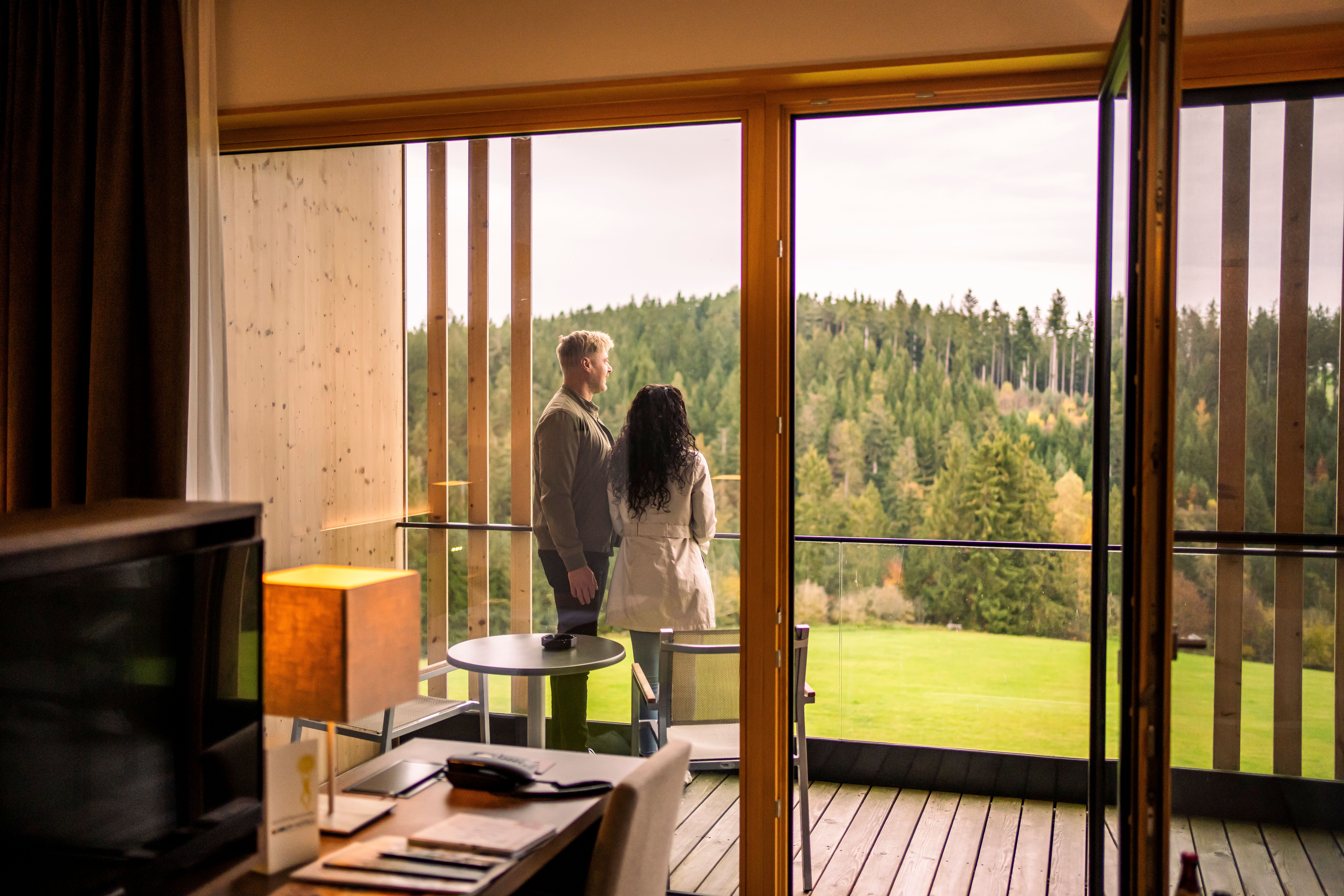 Hotel Schwarz Alm Zwettl with natural pond and sun loungers, surrounded by green countryside.