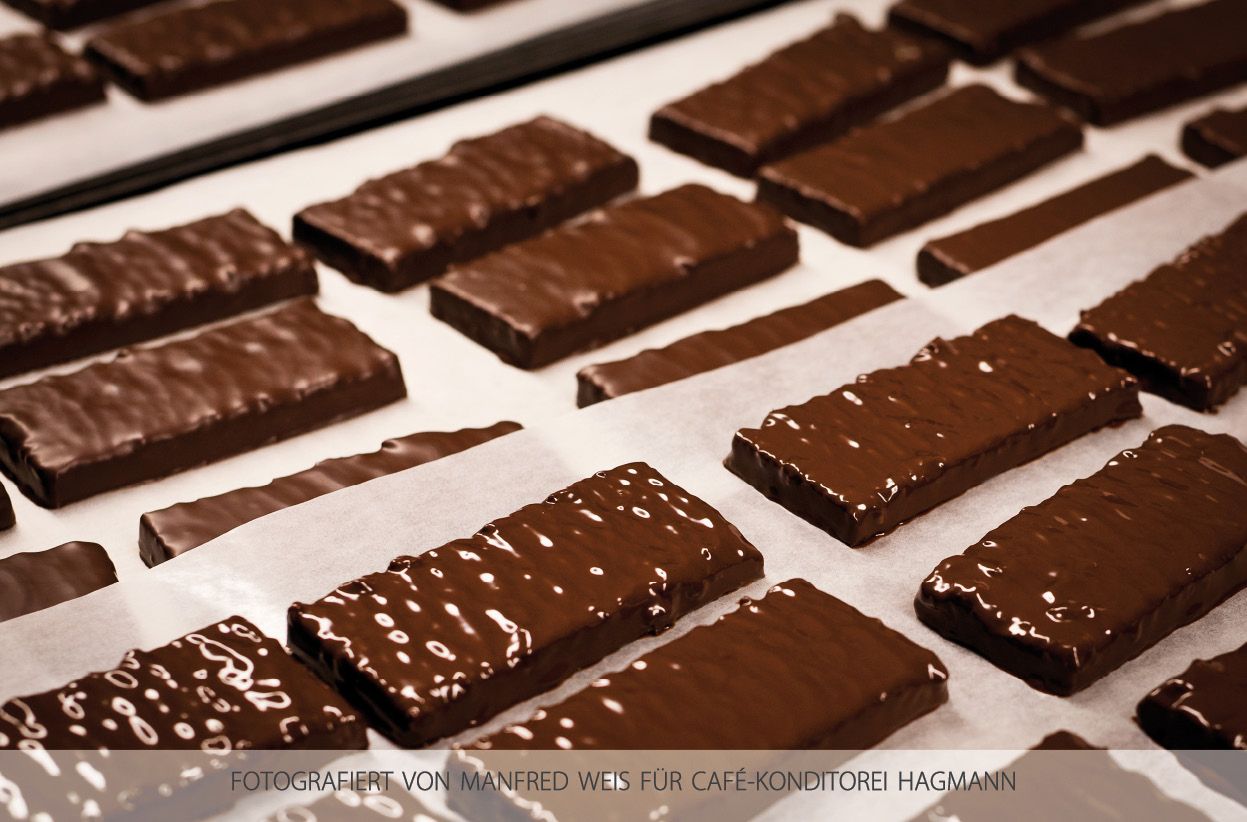 Chocolate-covered cookies on baking paper in a patisserie.