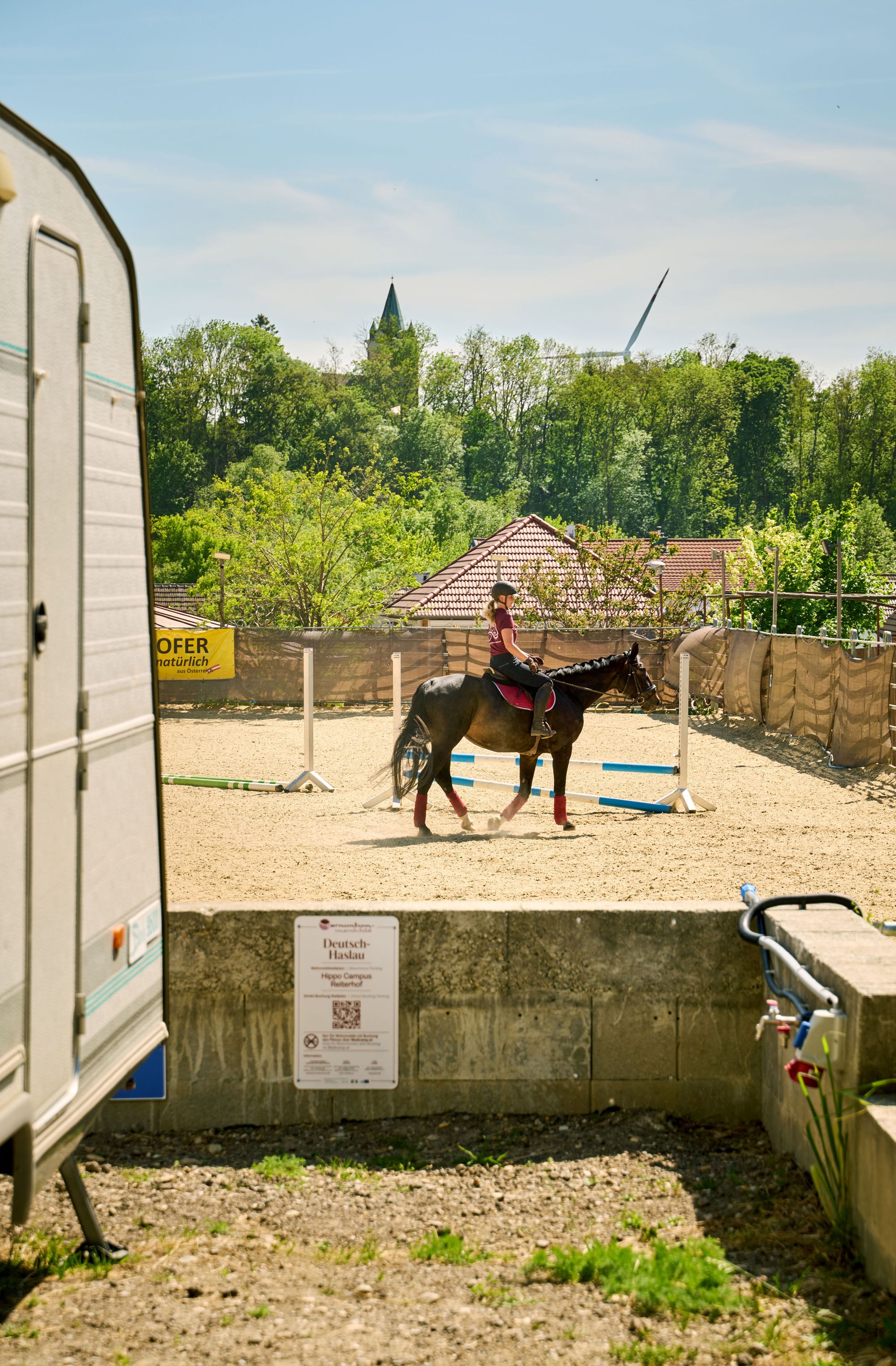 Lady on a horse and on the left of the picture you can see a caravan. 