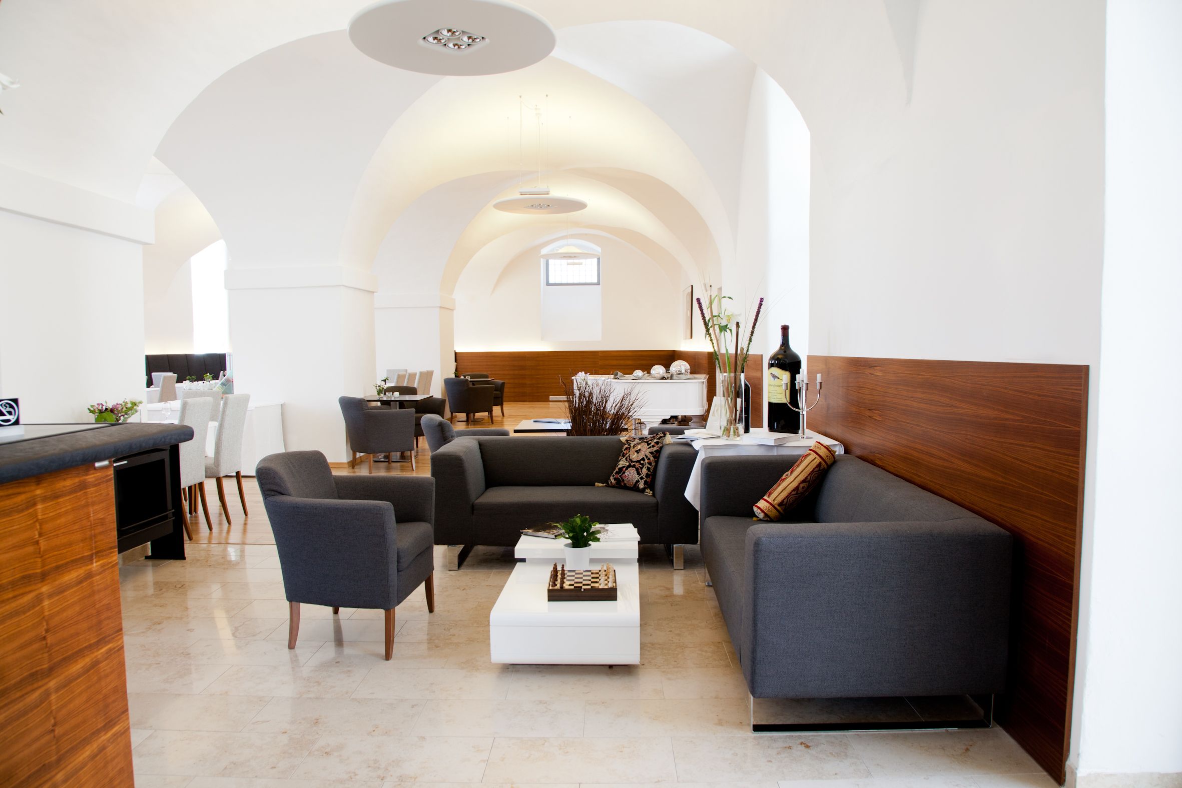 Elegant bar-restaurant with modern gray sofas and white walls.