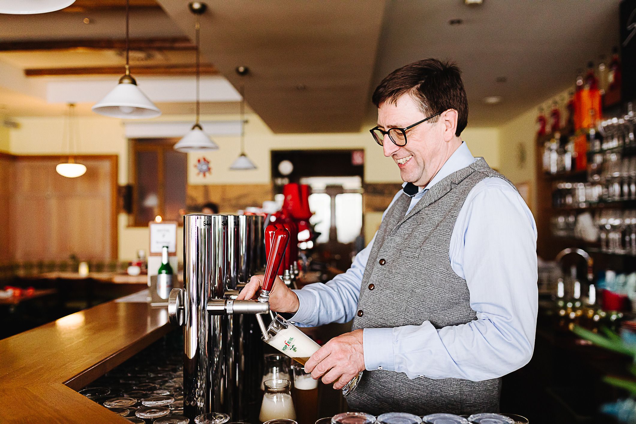 A man draws beer at a bar in a restaurant.