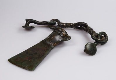Bronze Age tool with chain on a white background.