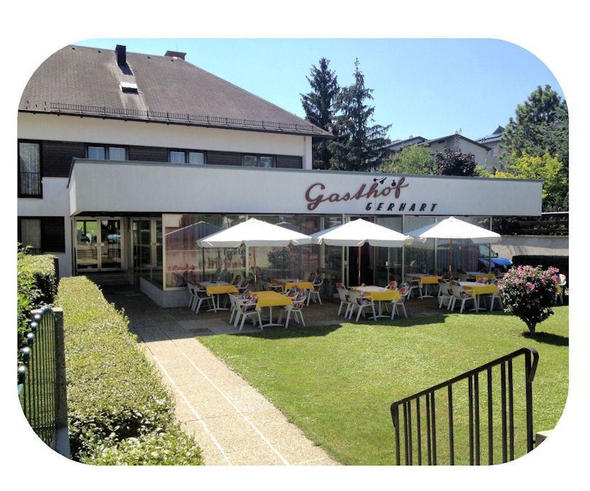 Exterior view of Gasthof Gerhart with terrace and parasols.