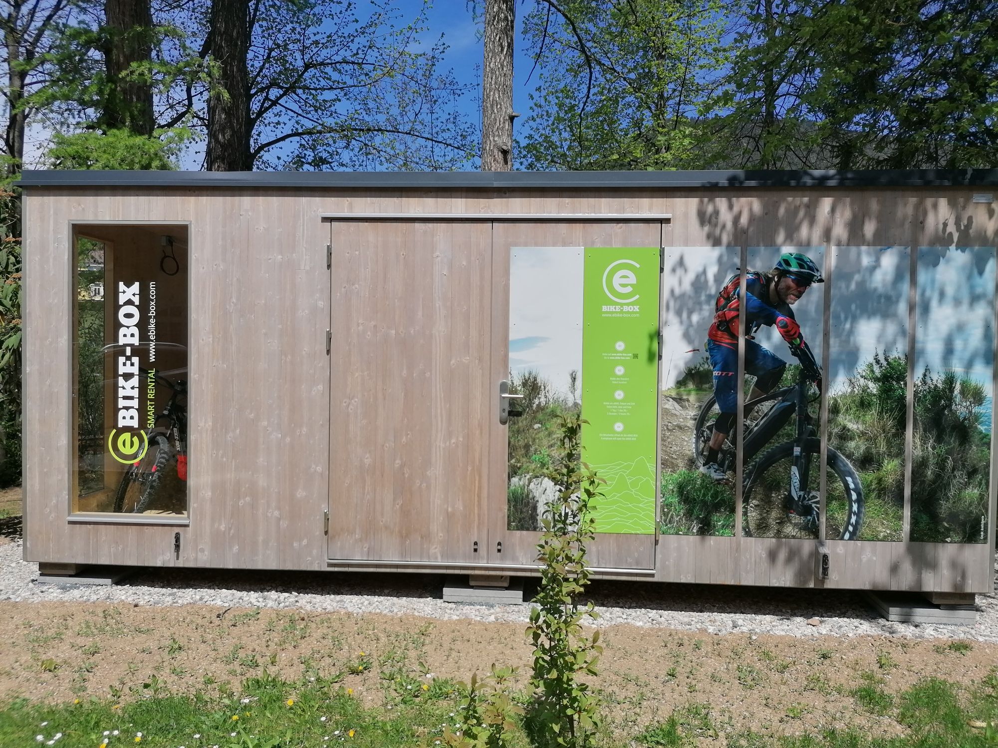 Wooden hut with e-bike advertising and picture of a cyclist.