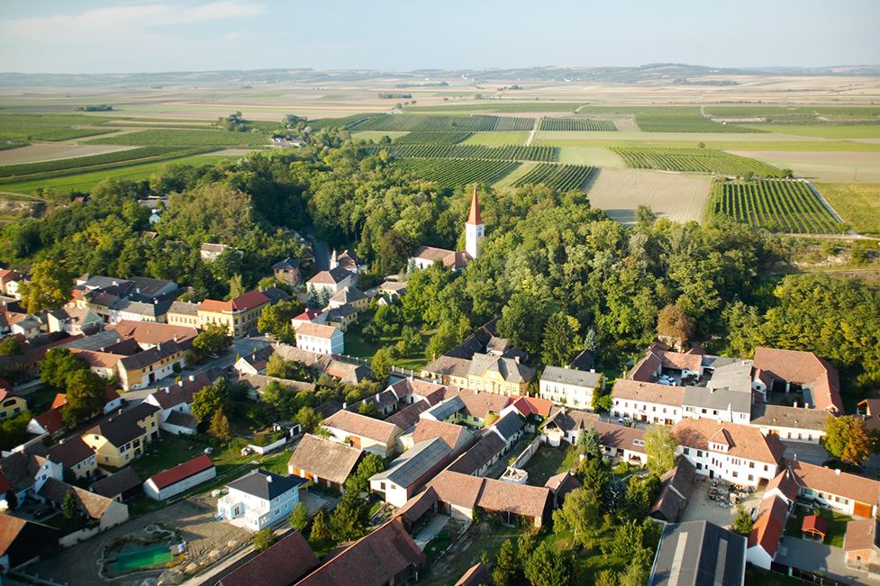 Aerial view of a village with church and surrounding fields.
