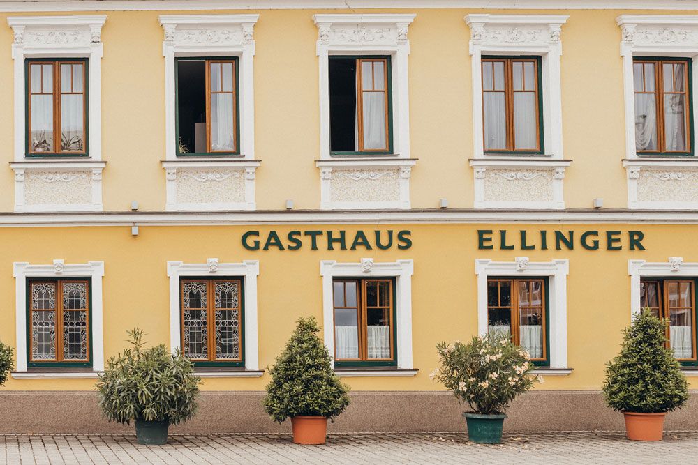 Façade of a yellow inn with the inscription 'Gasthaus Ellinger'.