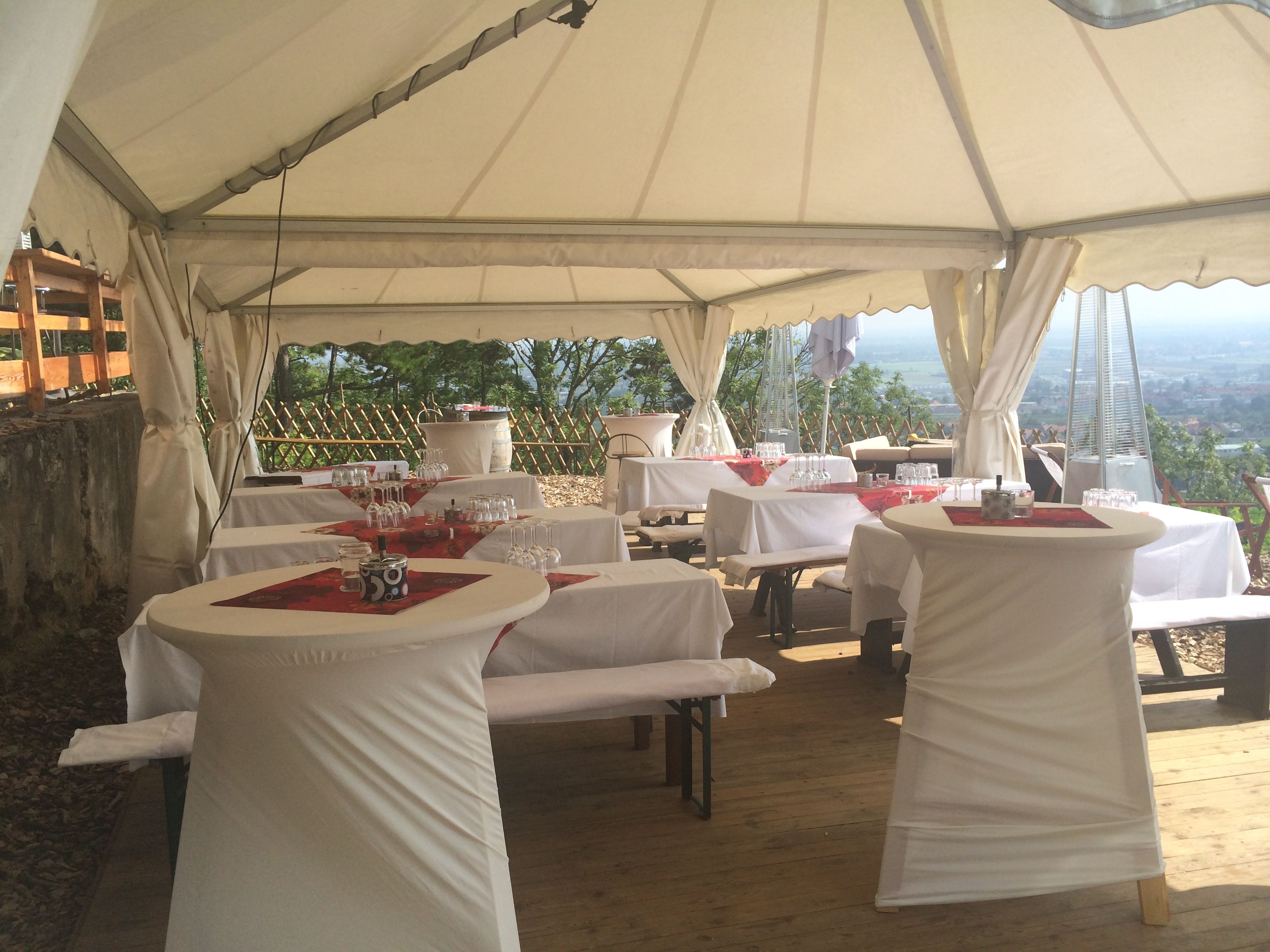Marquee with set tables and bar tables, decorated for a party.