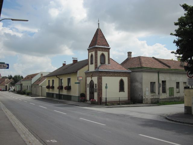 Street in Lanzendorf with church and residential buildings.