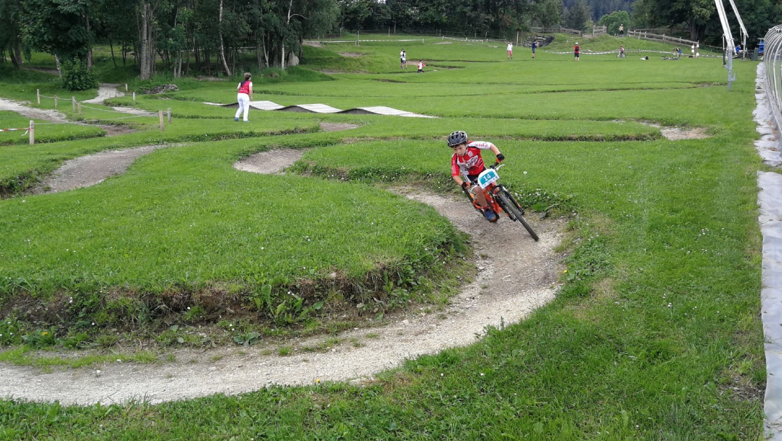 Child riding on a mini-bike parkour in the countryside.
