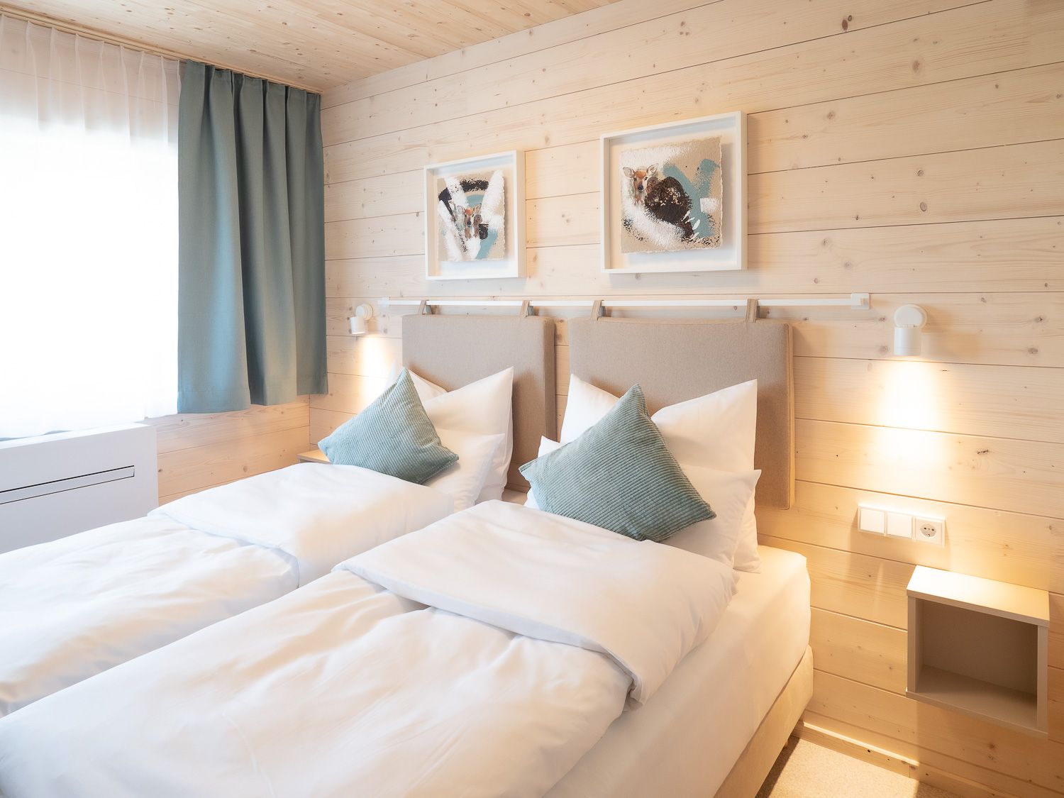 Cozy double room with two single beds, wooden walls and modern decoration.