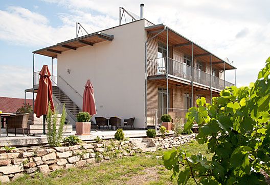 Modern building with terrace and garden in the foreground.