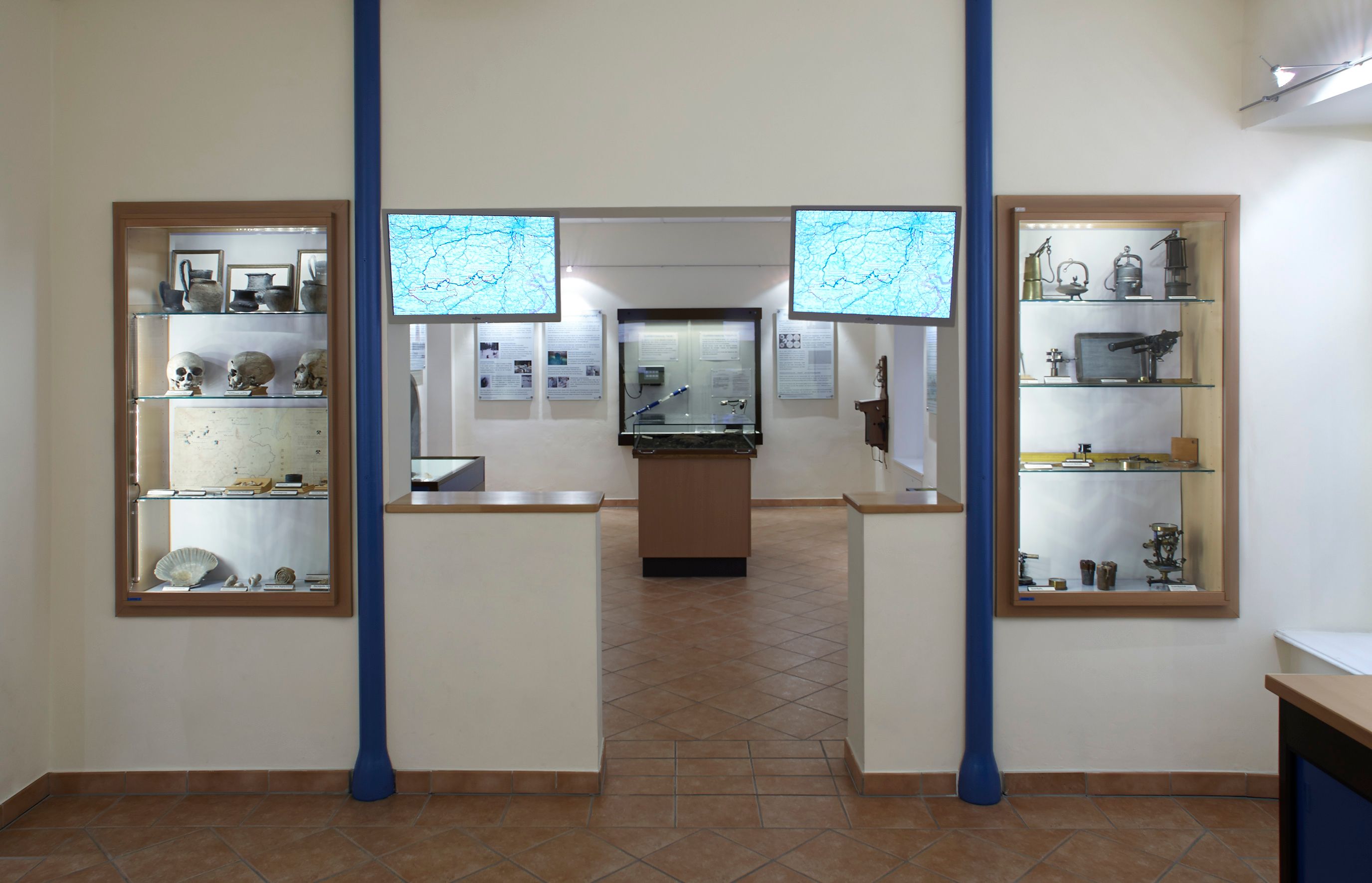 Interior view of the Kaiserbrunn water pipe museum with showcases and maps.