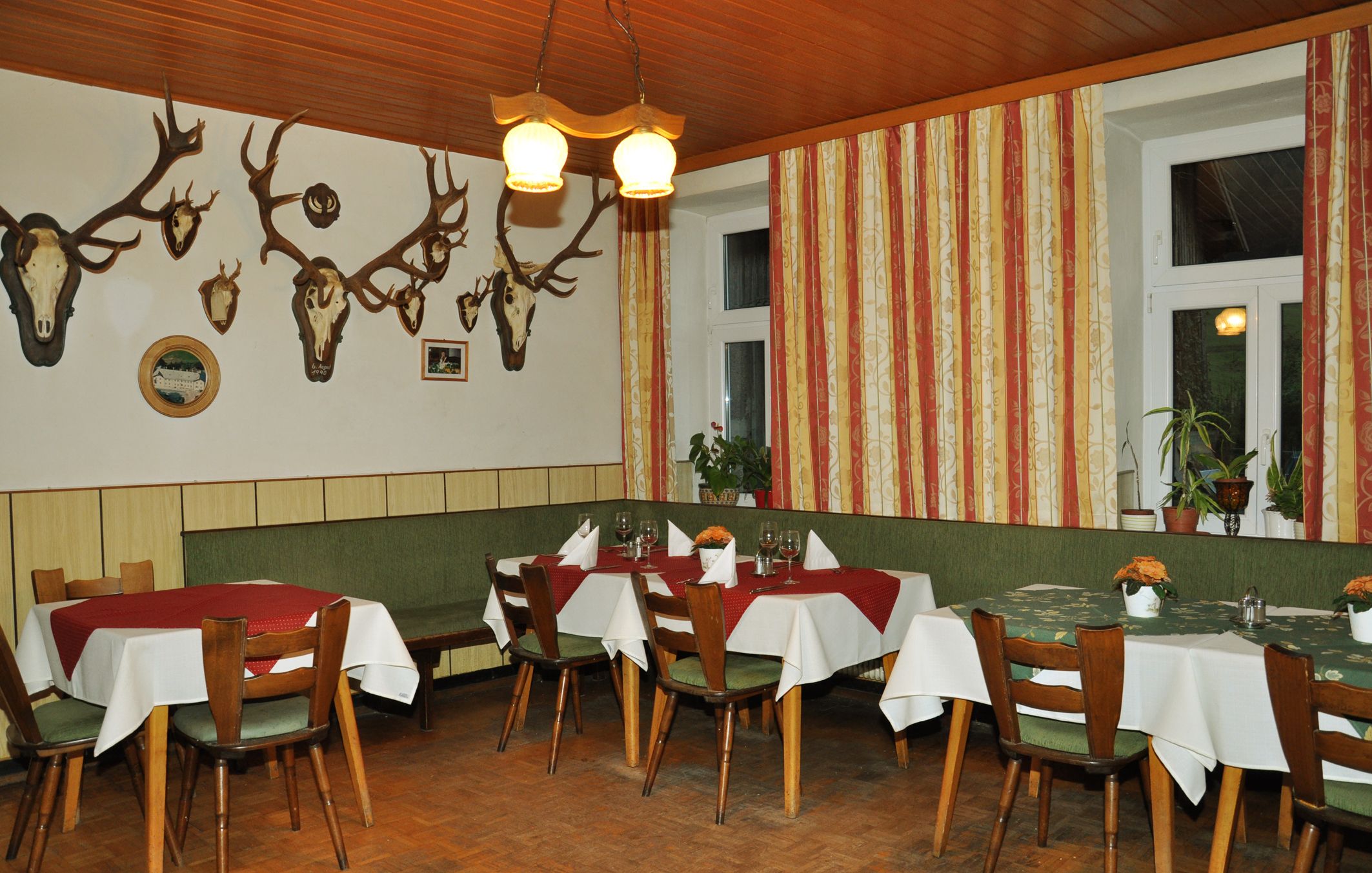 Interior view of a traditional inn with wooden furniture and antlers on the wall.