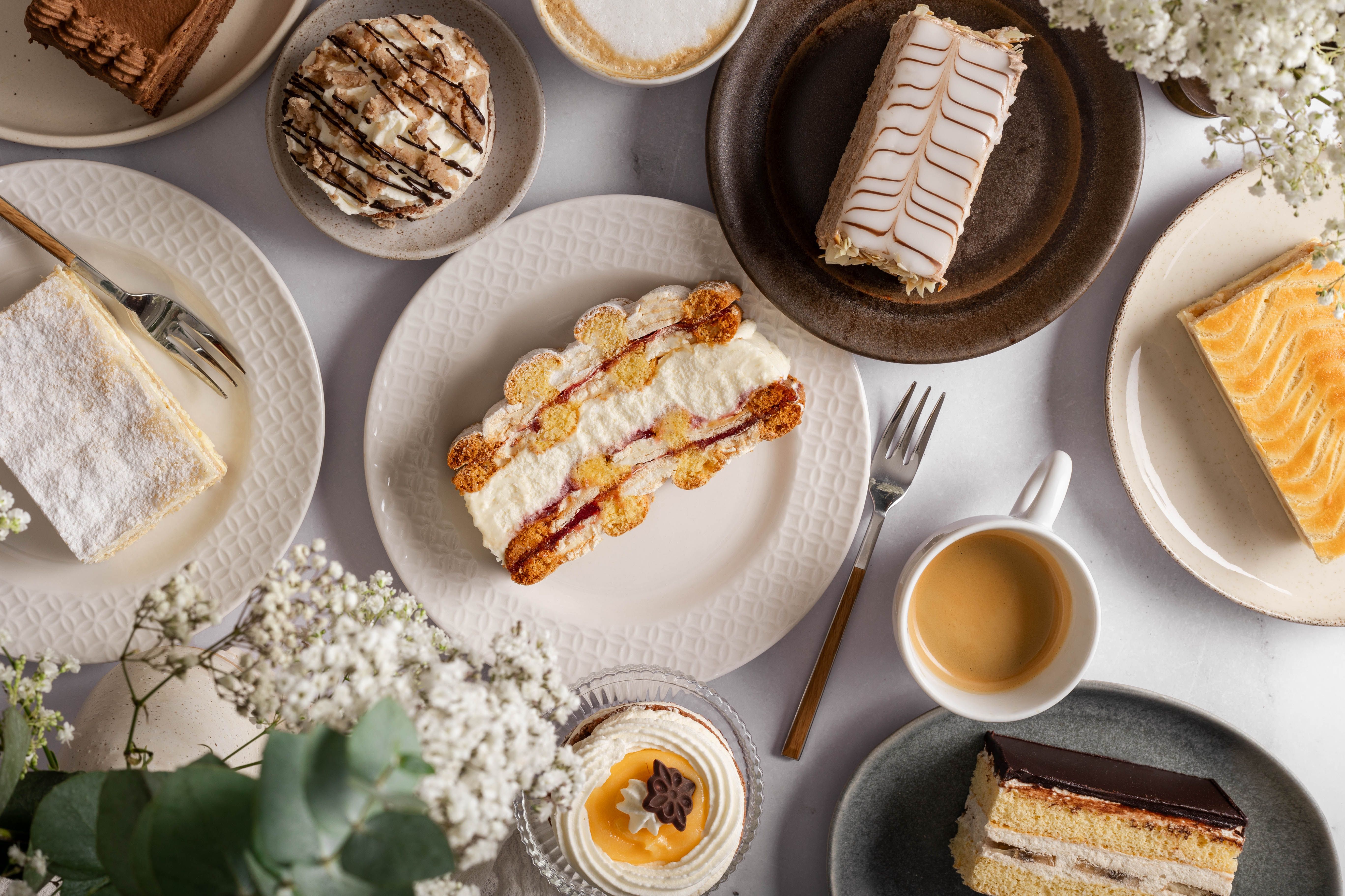 Various pieces of cake and a cup of coffee on a table.