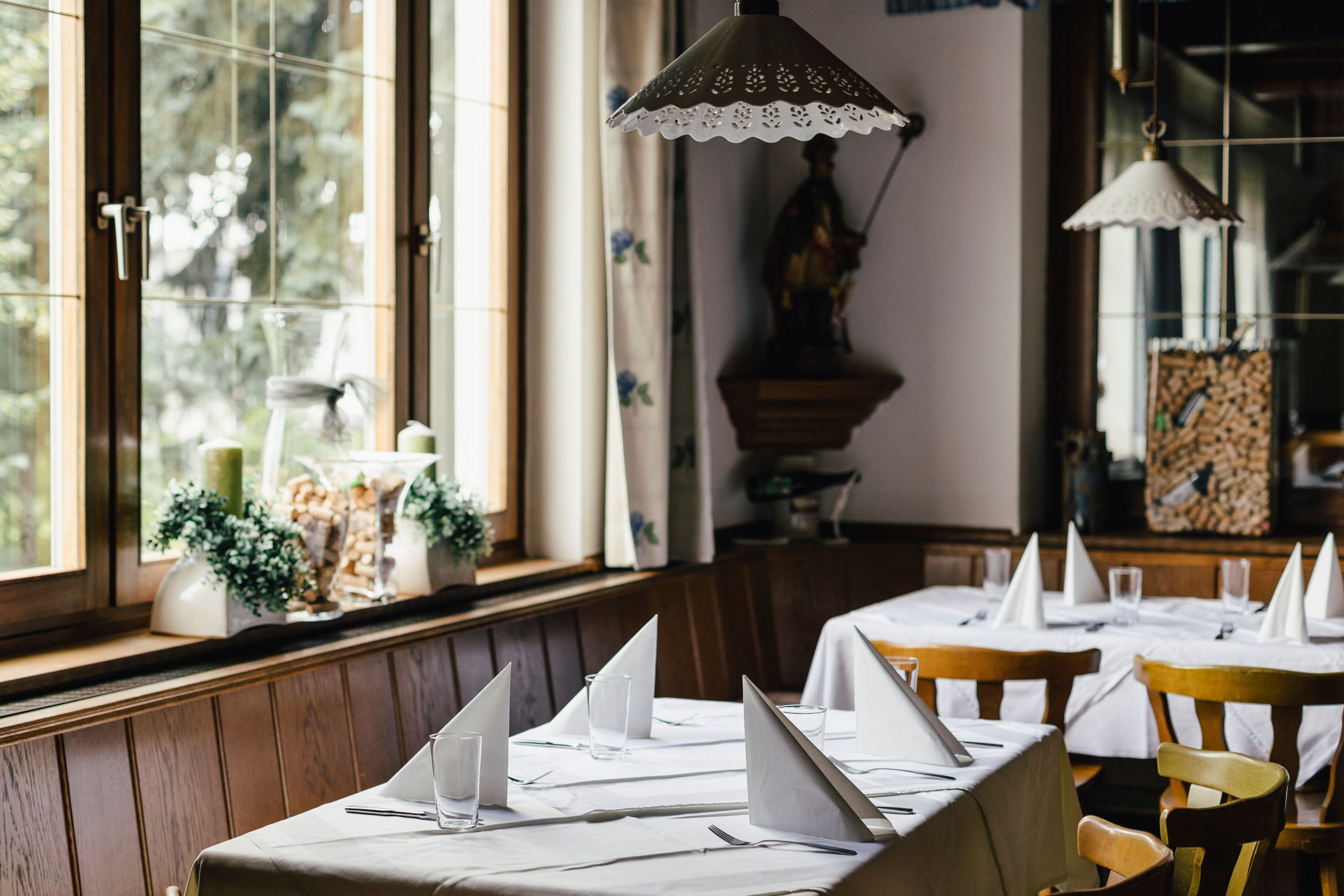 Interior view of a cozy restaurant with set tables and wooden chairs.