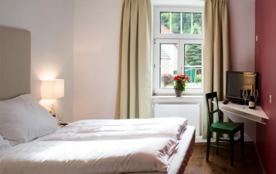 Double bed with window and table corner with TV