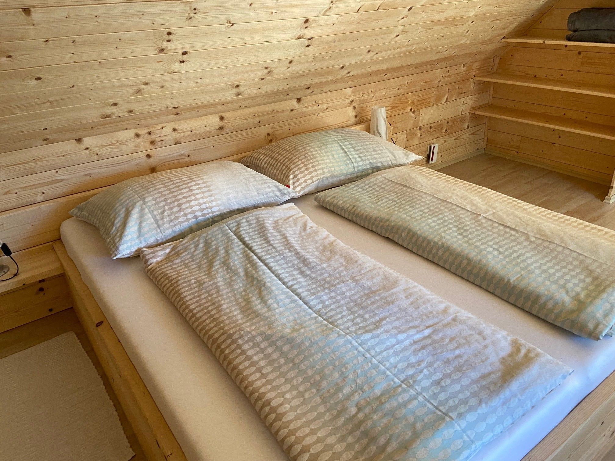 Double bed in a room with wooden paneling.