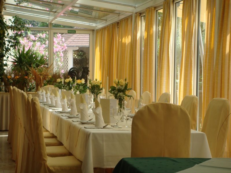Elegant conservatory with table setting and yellow curtains.