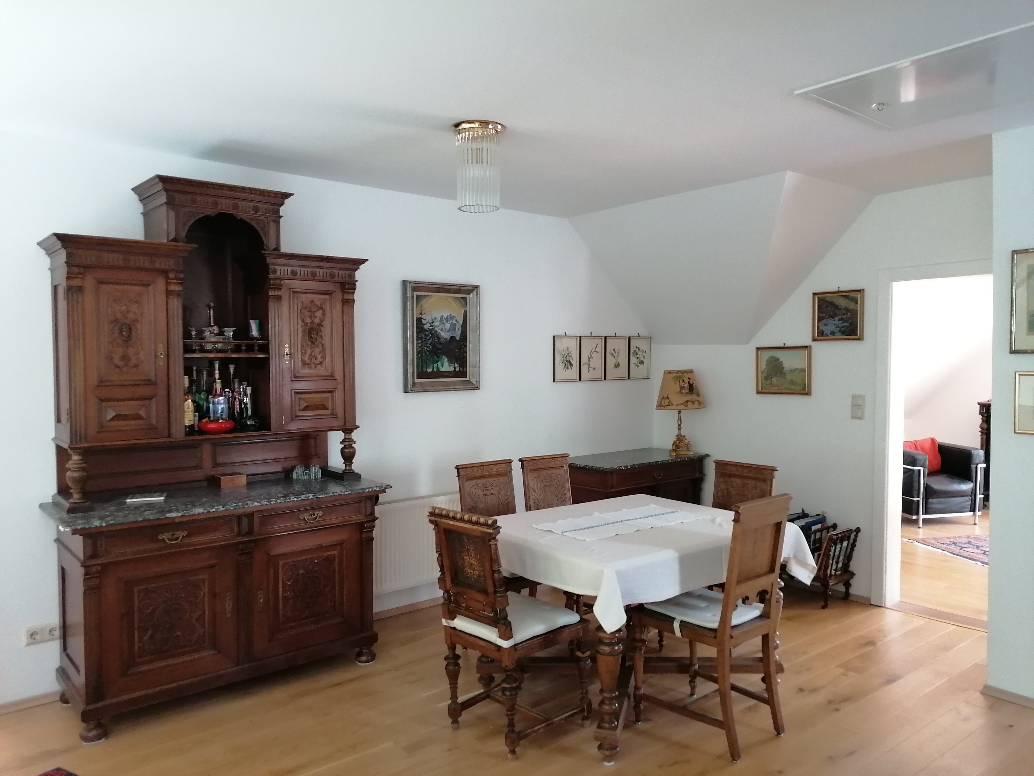 Dining area with antique wooden furniture and dining table with chairs.