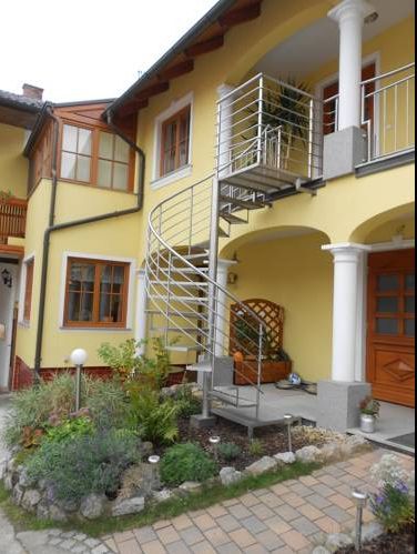 Yellow house with spiral staircase and garden.