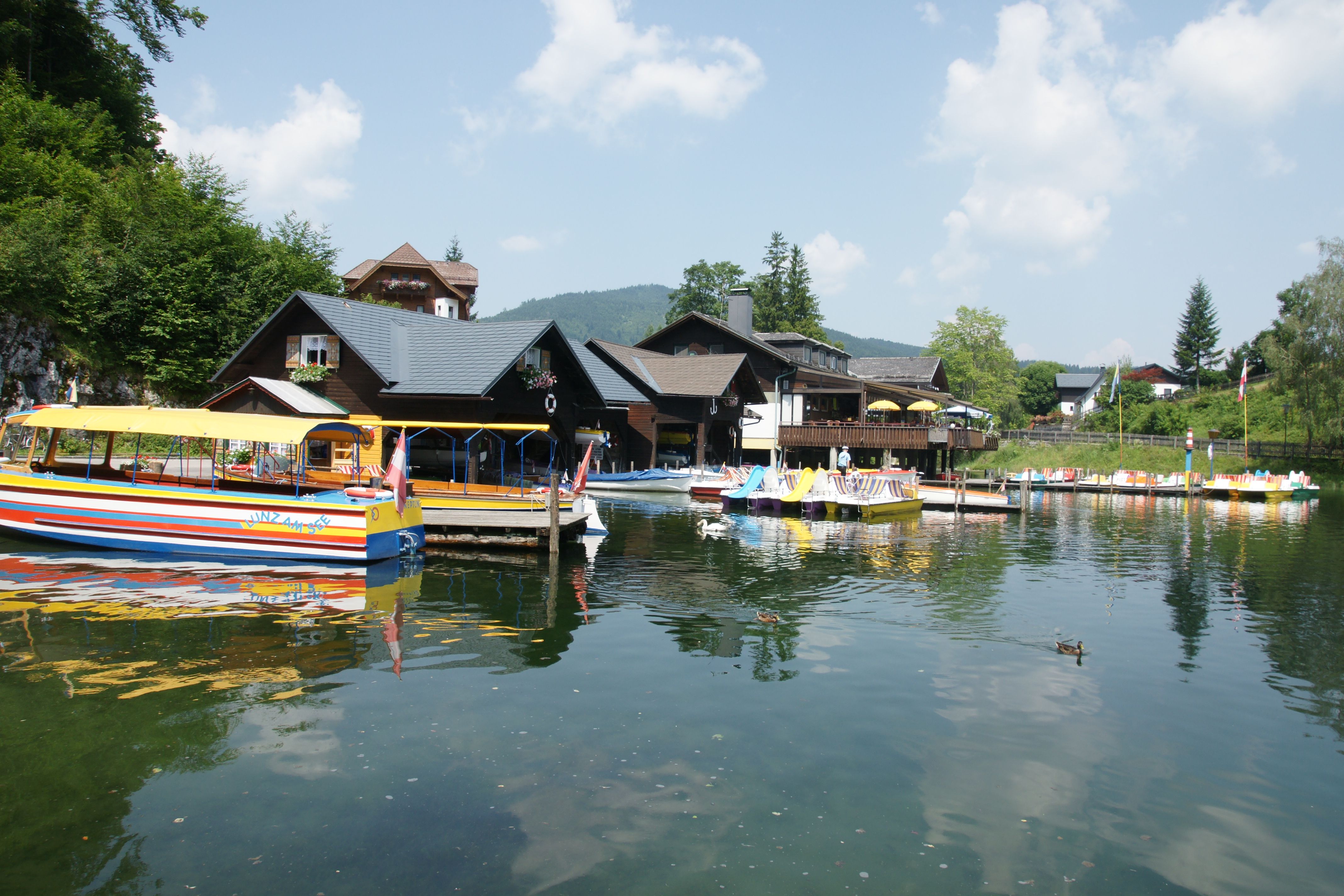 Boats and buildings on the shore of Lake Lunz on a sunny day.