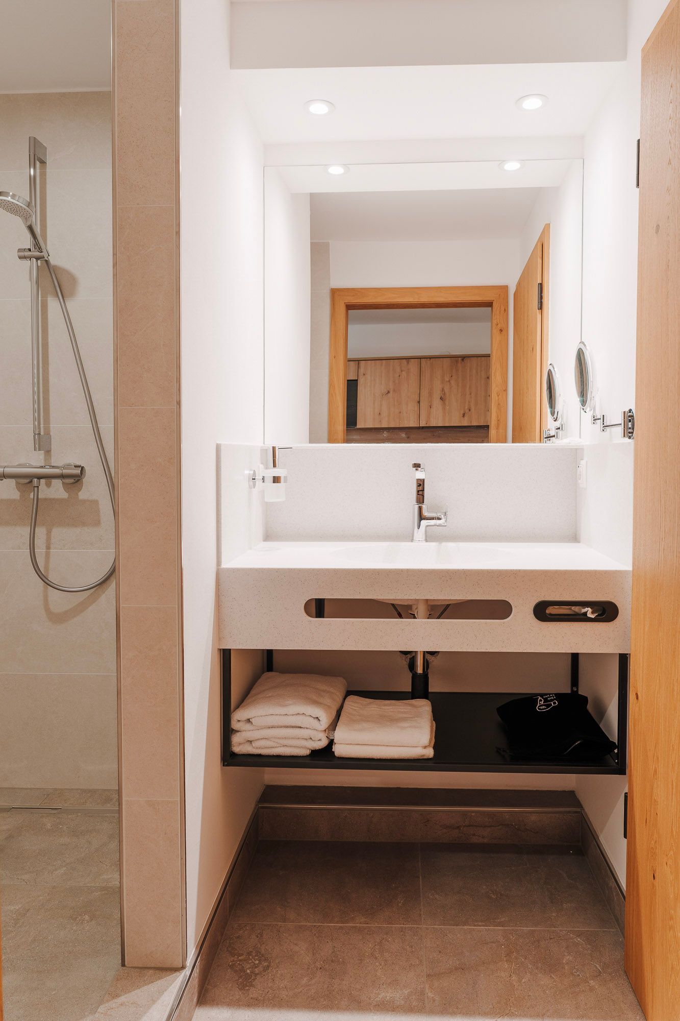 Modern bathroom with washbasin, mirror and shower.