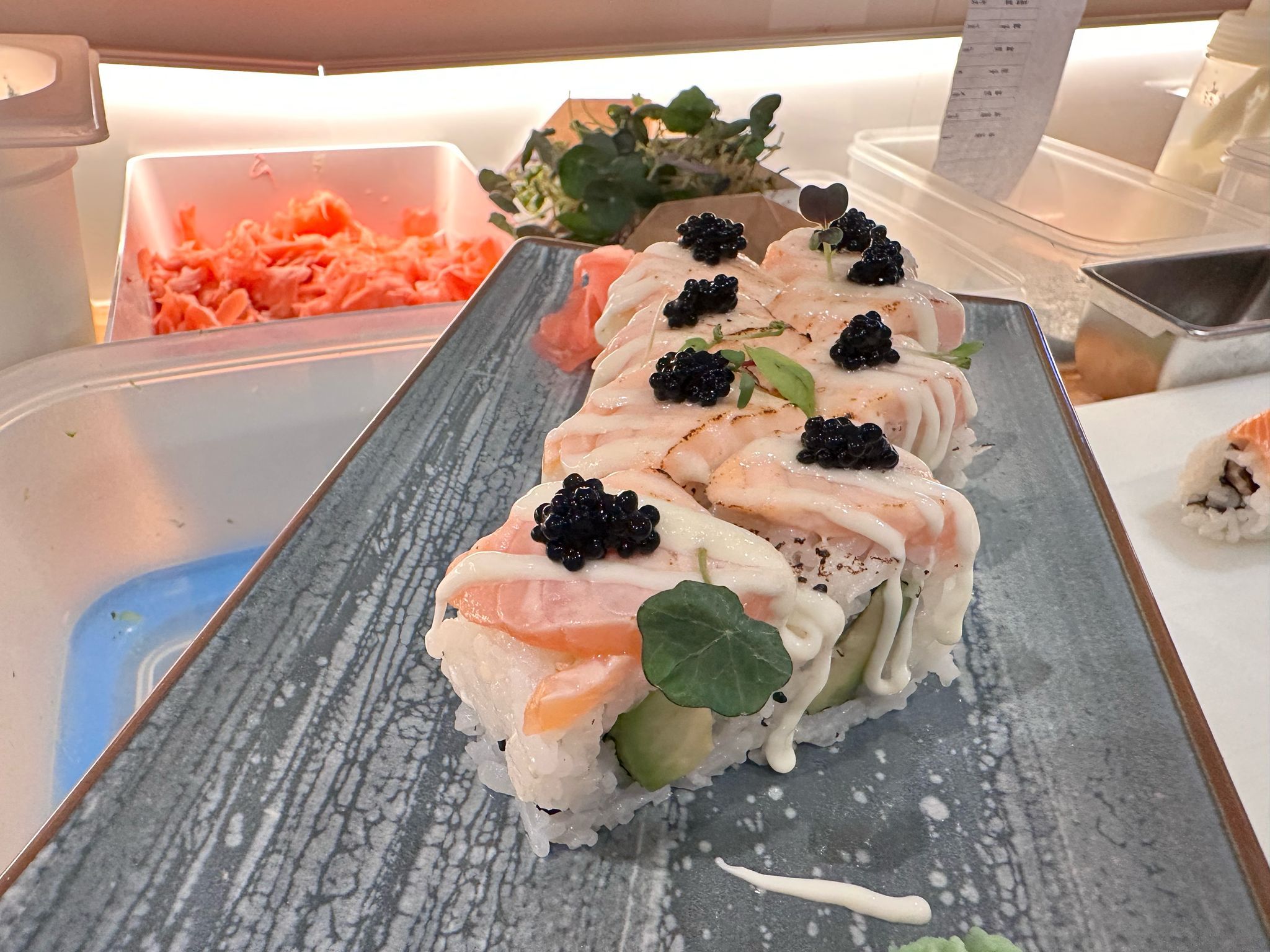 Sushi rolls with salmon and caviar on a plate.