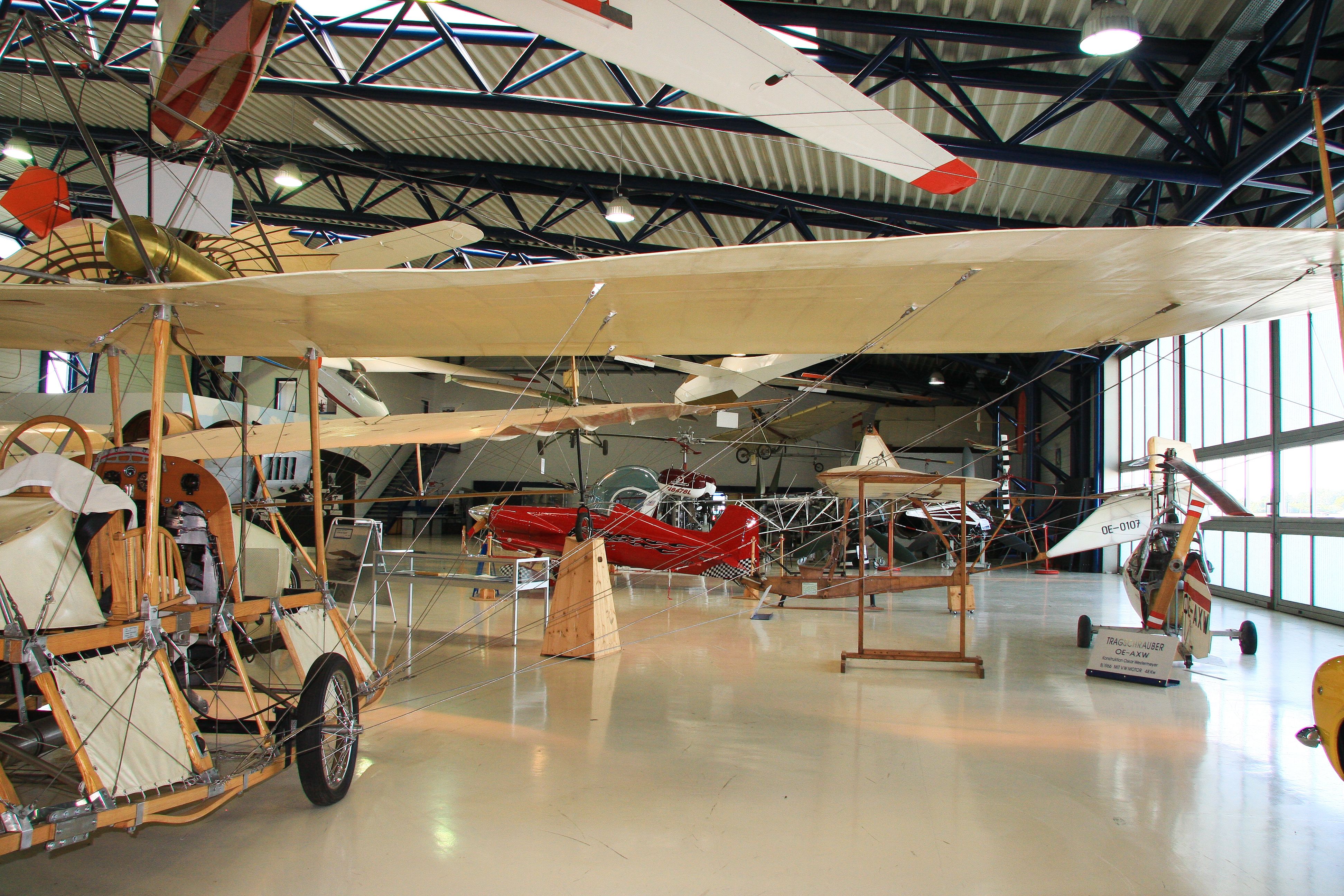 Interior view of an aviation museum with historic airplanes and gliders.