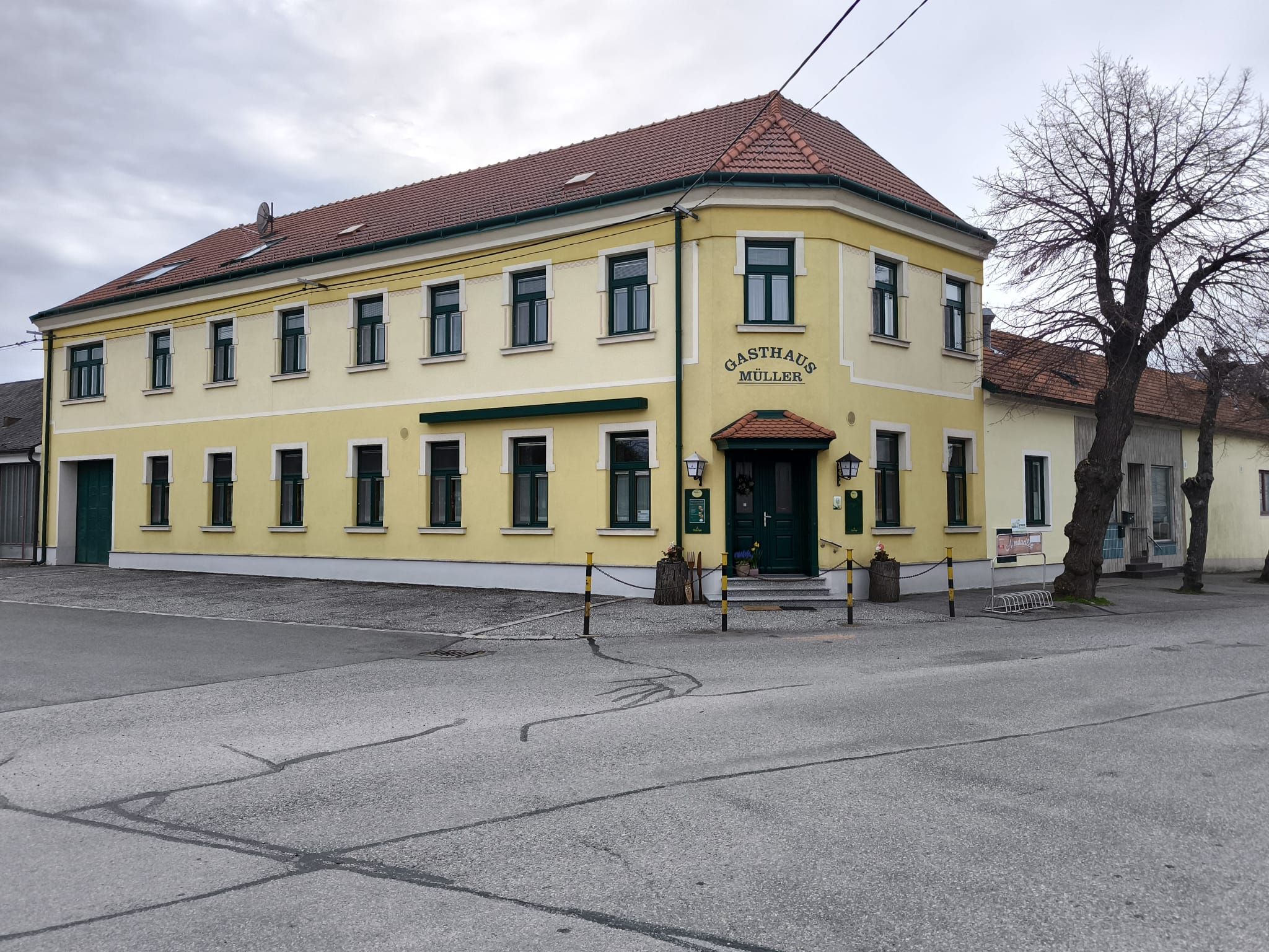 Yellow two-story building with the inscription 'Gasthaus Müller'.