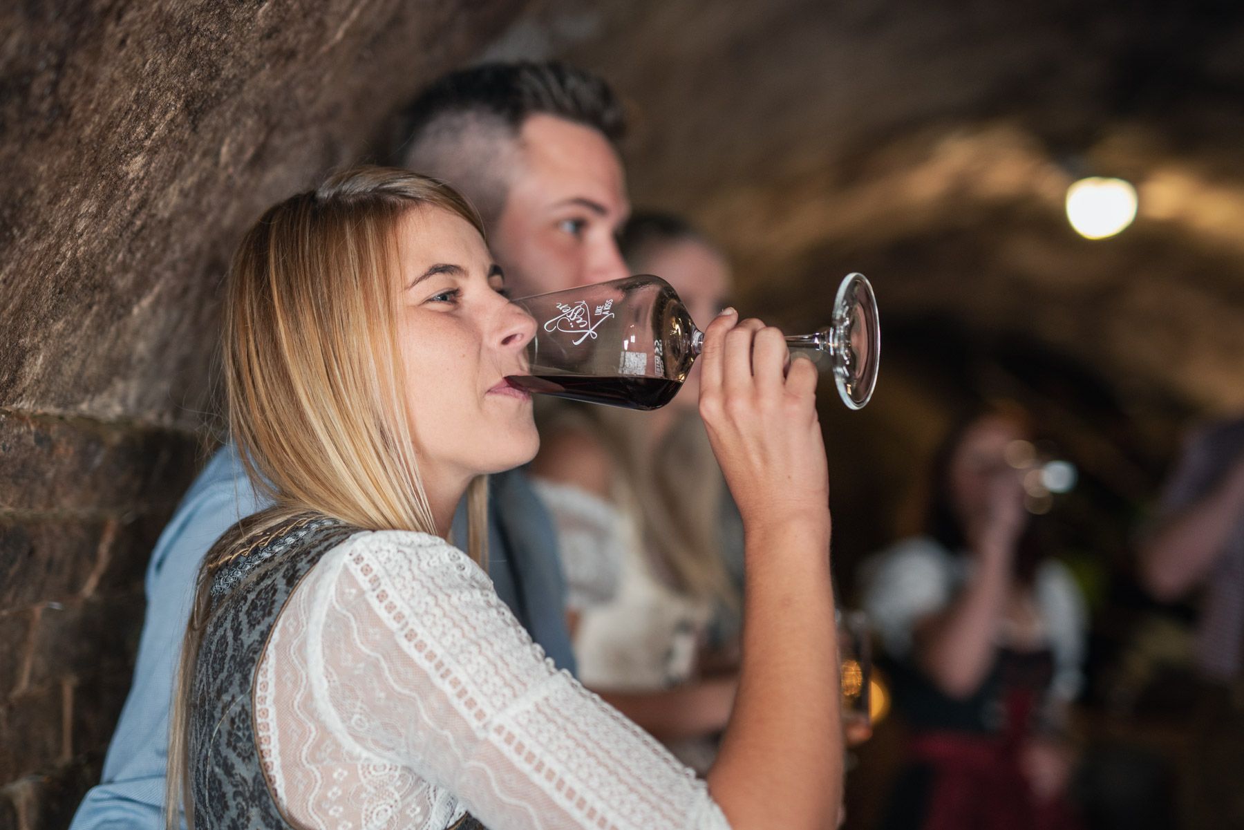 Woman drinking wine in a wine cellar.