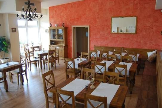 Interior view of a restaurant with wooden furniture and red walls.