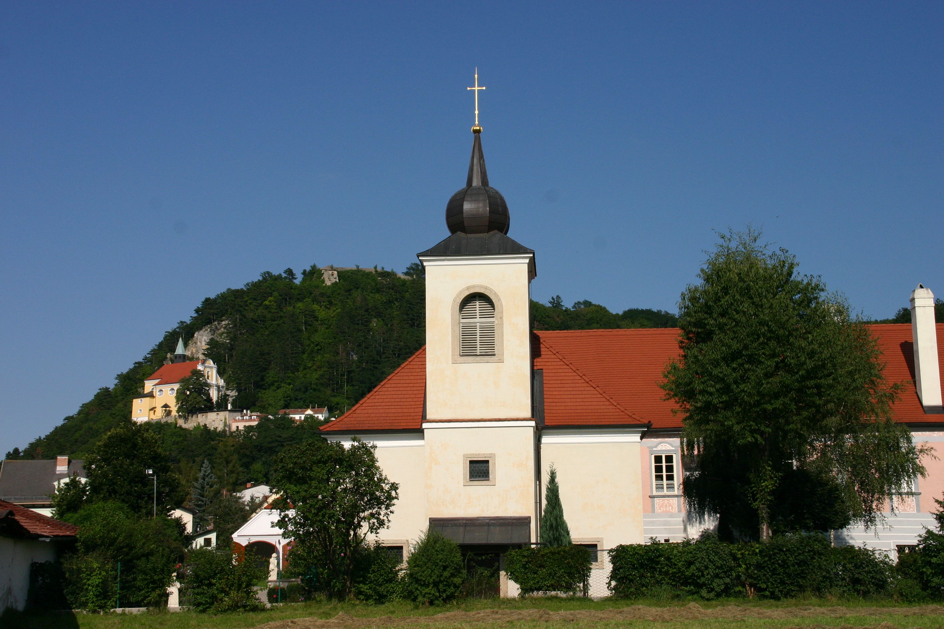Pitten vicarage with church and hill in the background.