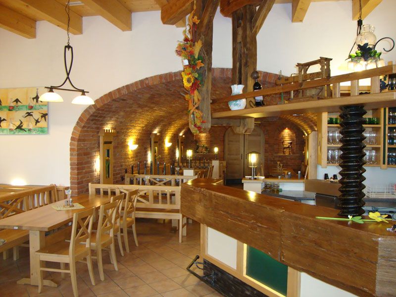 Interior view of a traditional wine tavern with wooden furniture and brick walls.
