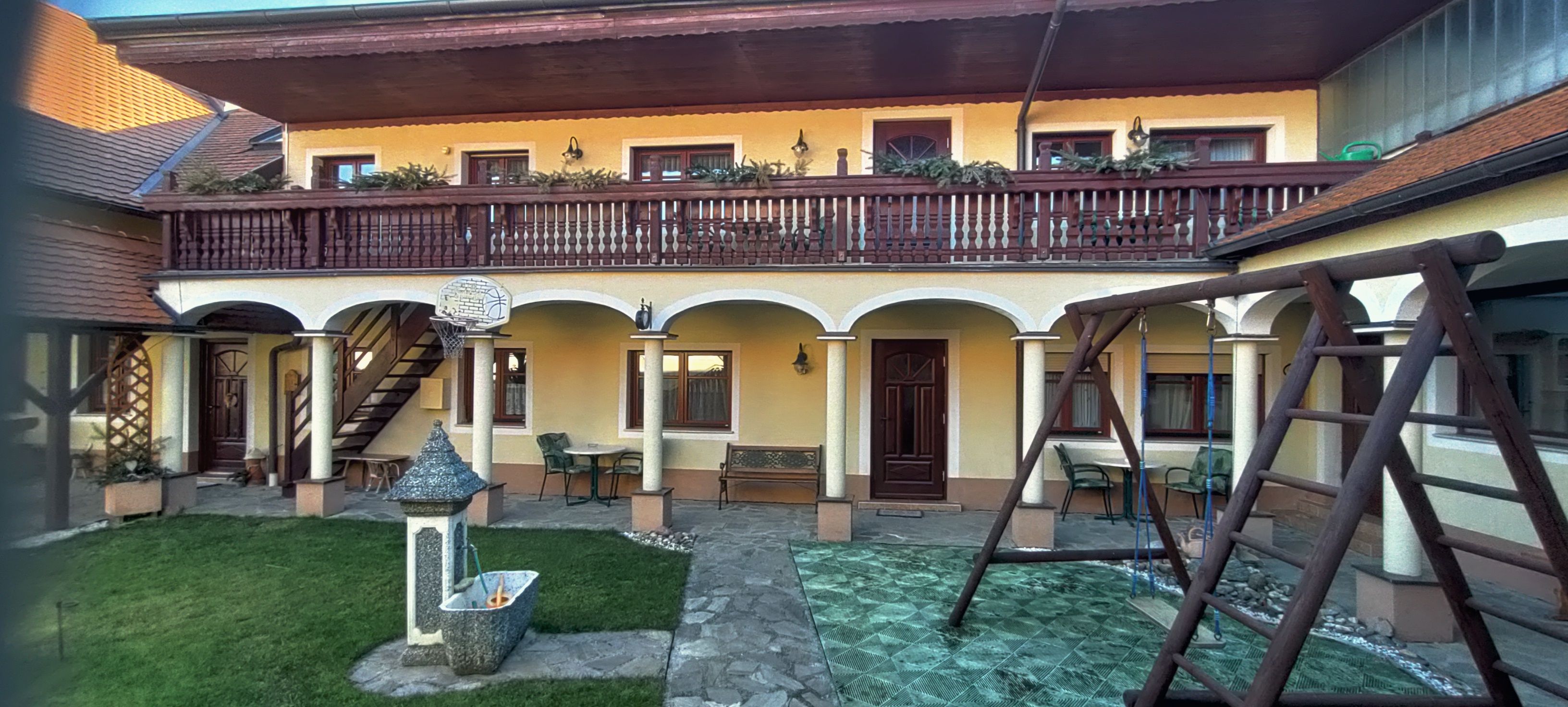 Inner courtyard with arcades, balcony, swing and fountain.
