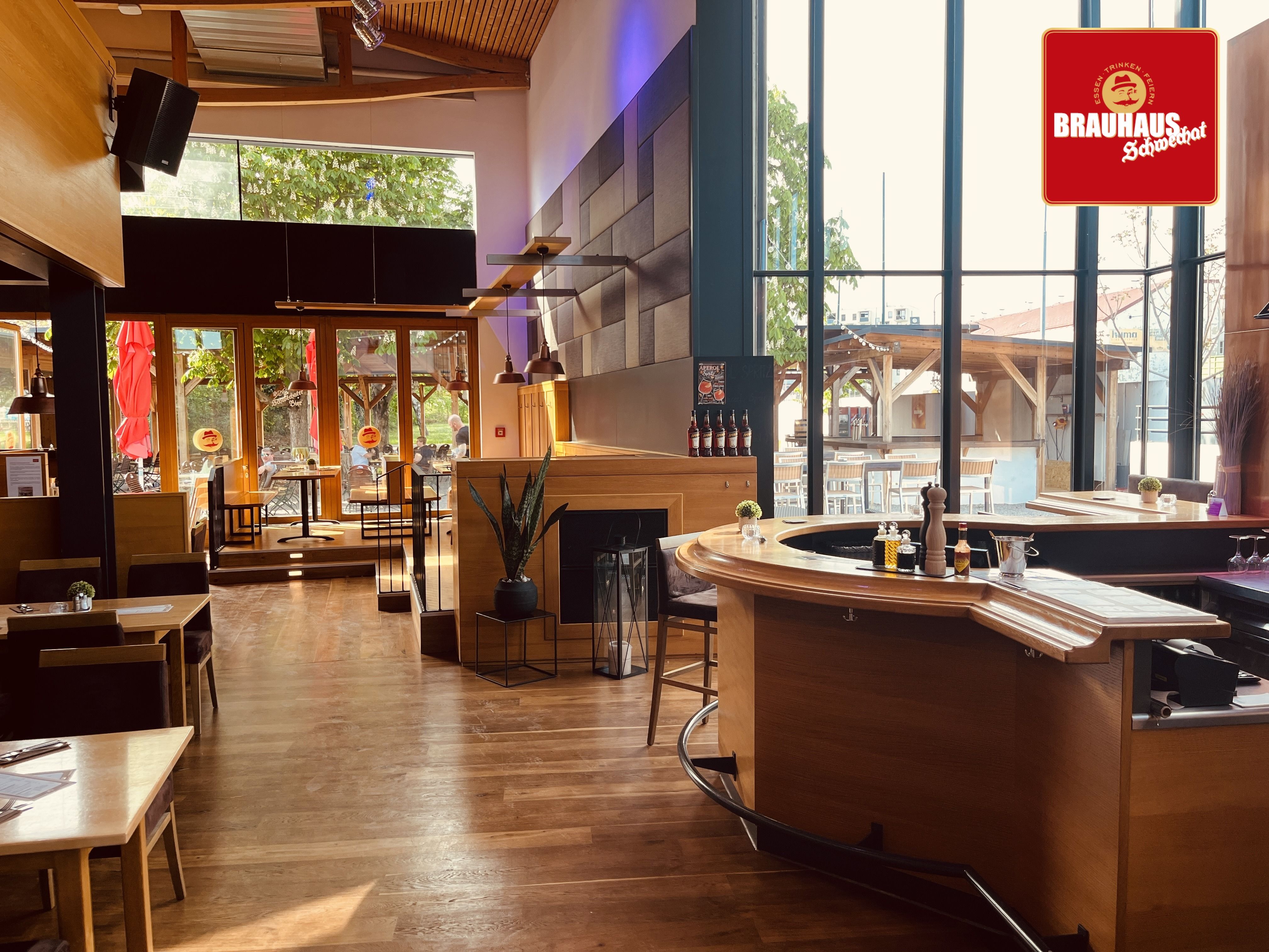 Interior view of a modern brewery with wooden furniture and large windows.