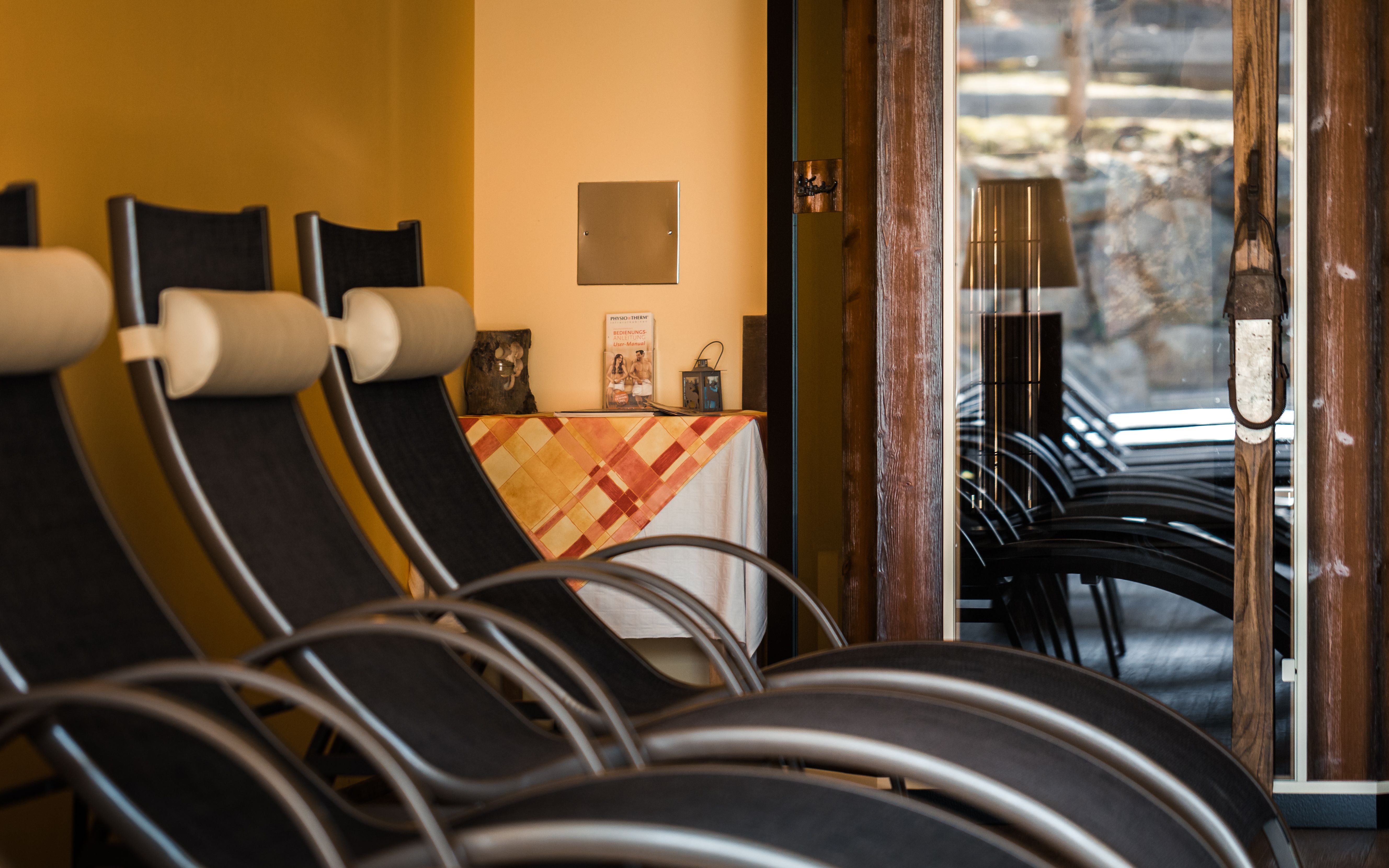 Interior view of a relaxation room with deckchairs and a table with tablecloth.