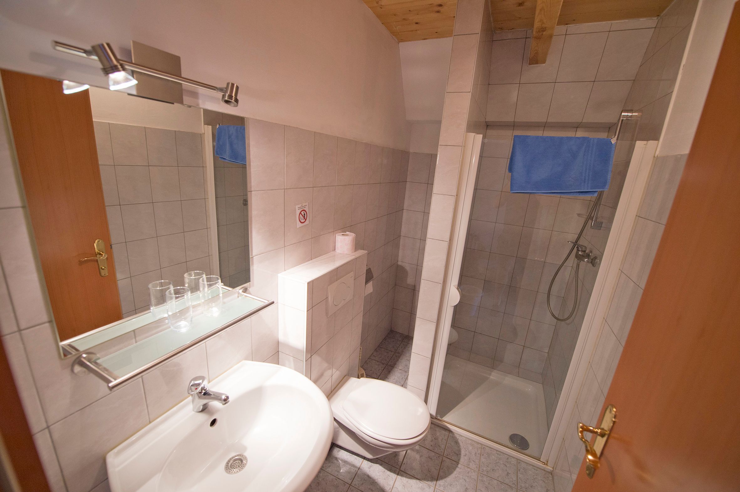 Bathroom with washbasin, mirror, shower and toilet.