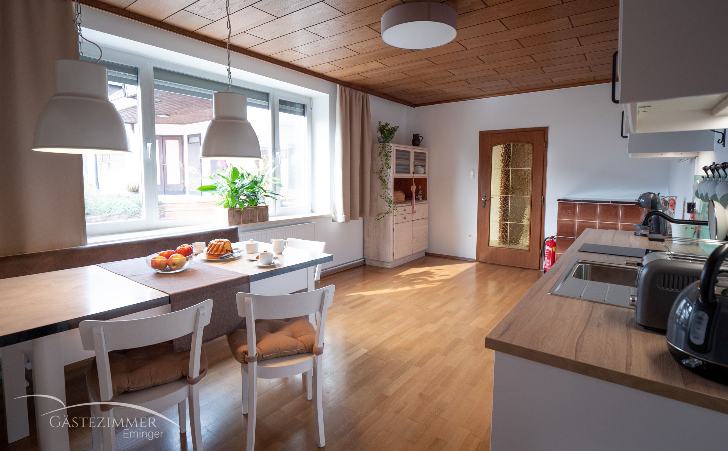 Modern eat-in kitchen with dining table, chairs and kitchenette.