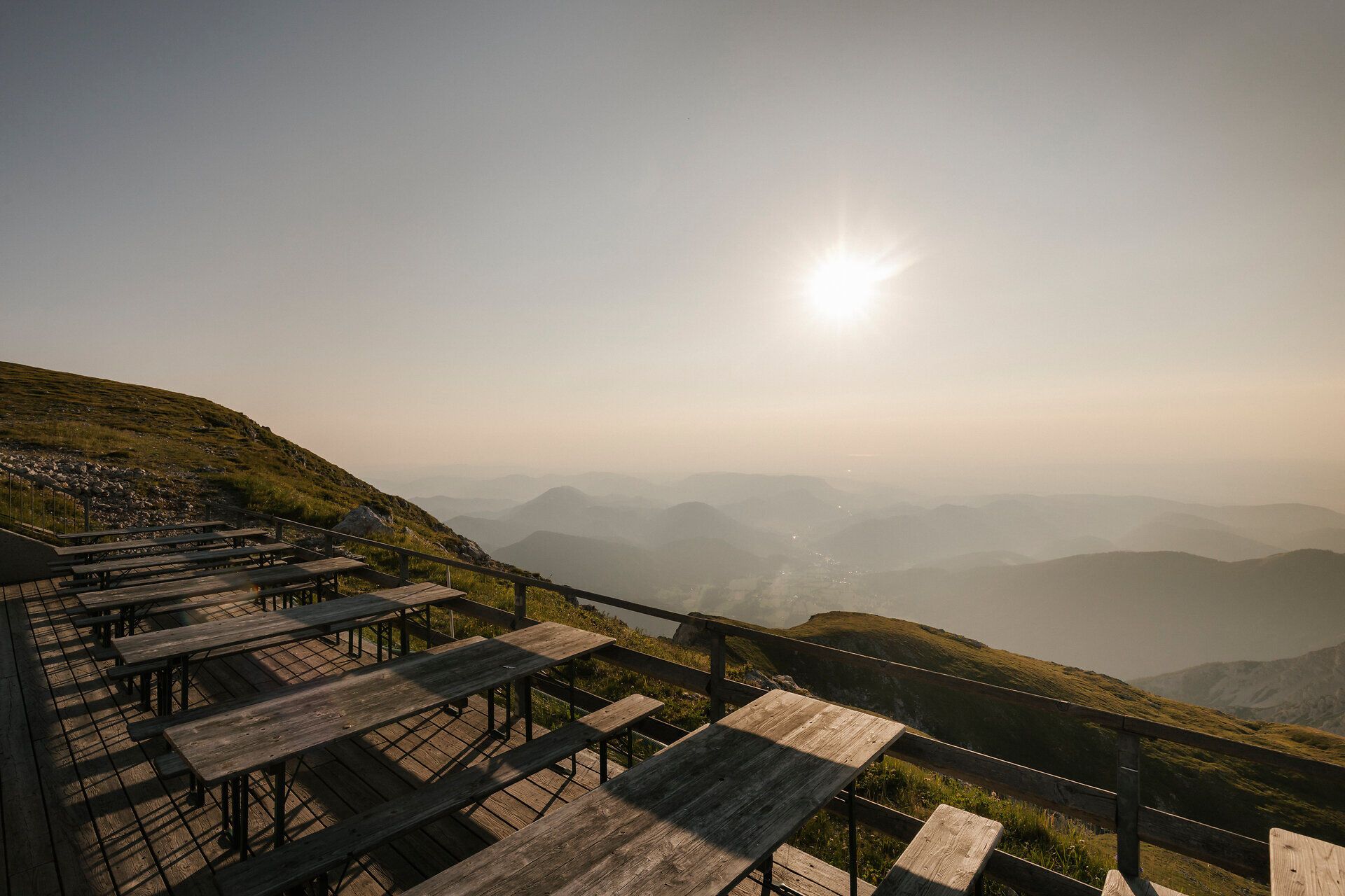 Sun terrace at the Fischerhütte on Schneeberg, with wooden tables and sweeping views of the mountain landscape