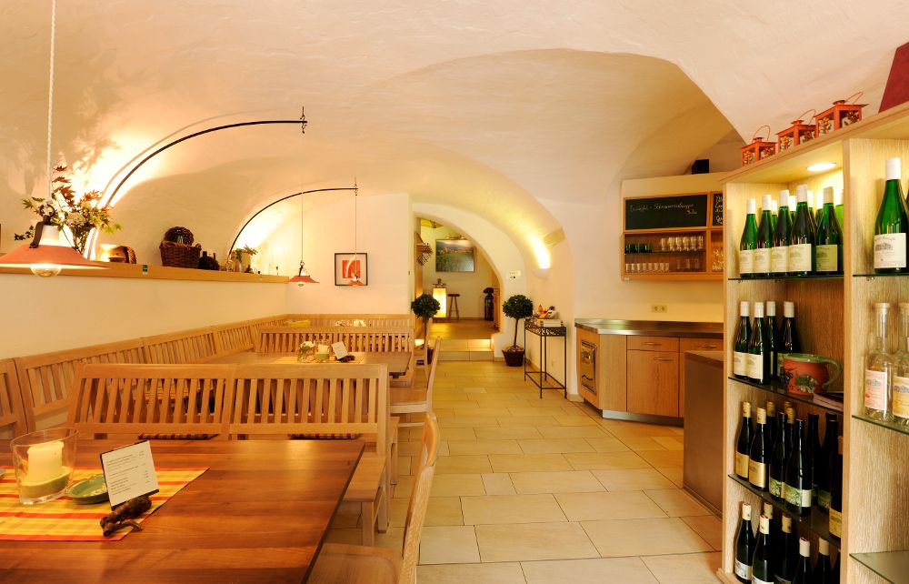 Interior view of a cozy wine tavern with wooden tables and wine racks.