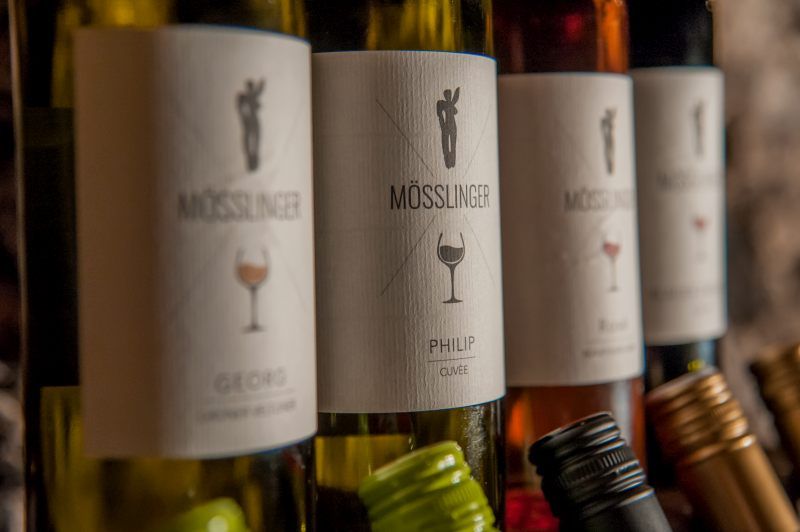 Close-up of wine bottles with Mösslinger brand labels.