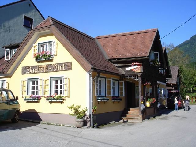 A traditional inn with a yellow façade and flower boxes under the windows.