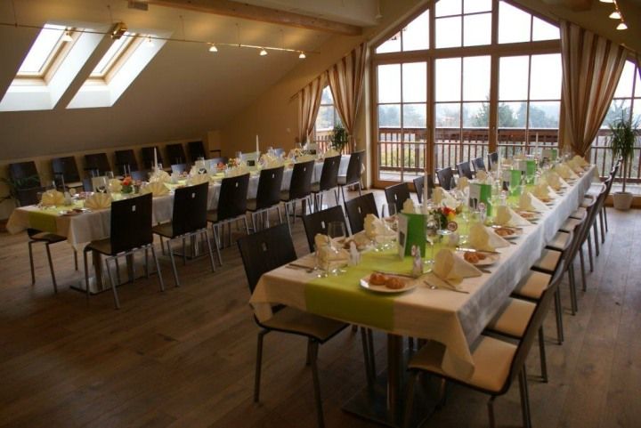 A festively decorated hall with long tables and chairs in a country inn.