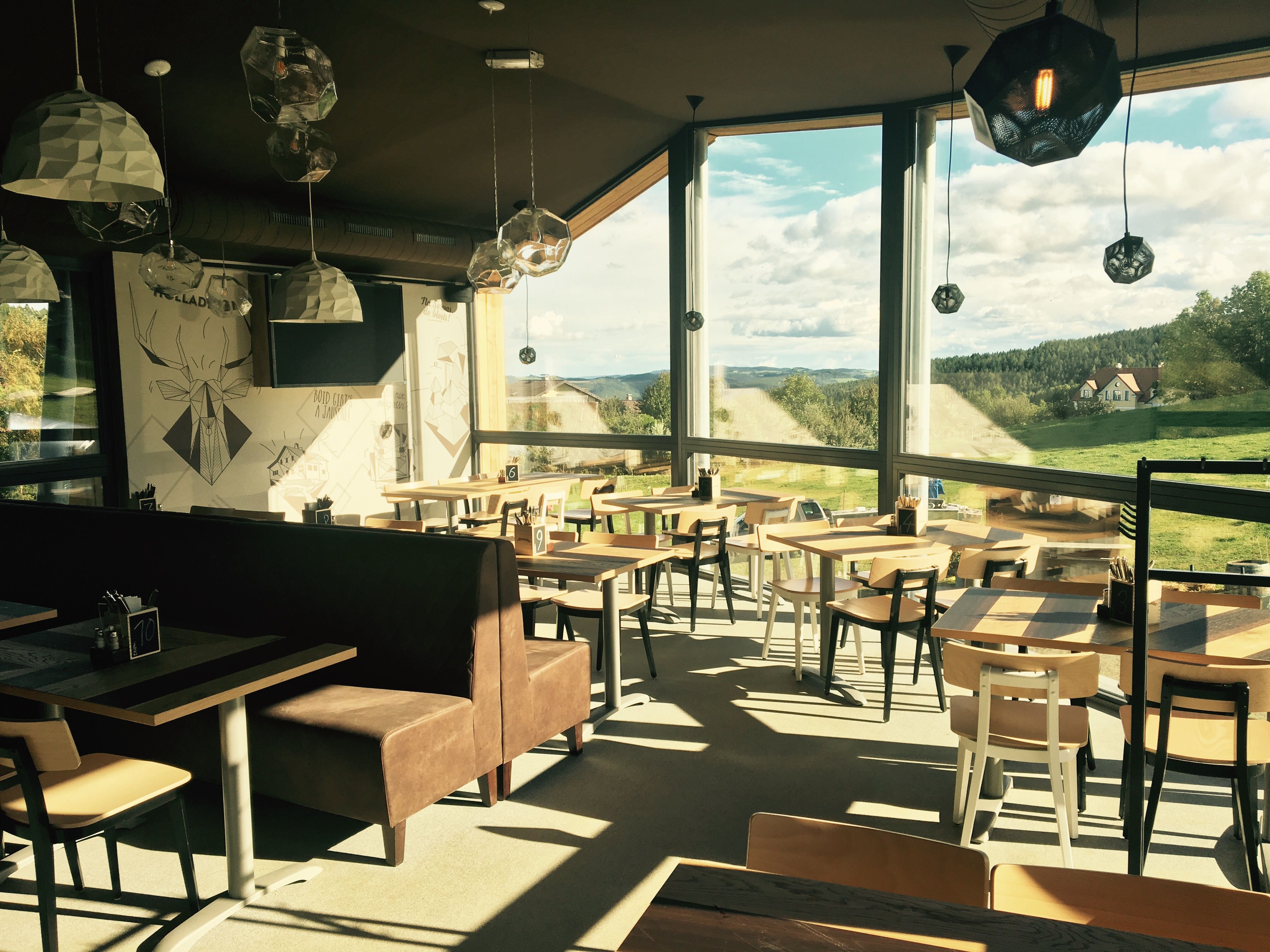 Interior view of the Wexl Lounge with large windows and a view of the countryside.